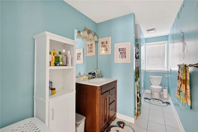 a white toilet sitting next to a bathroom sink and vanity