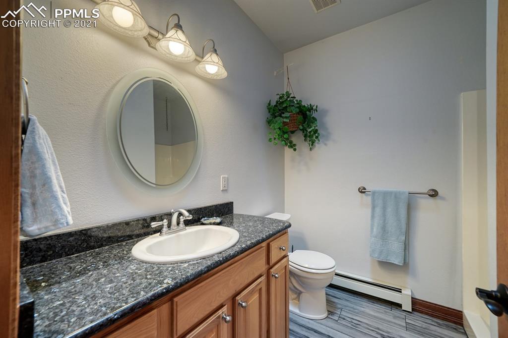 13770 Woodlake Road Elbert, CO 80106 - Photo 13 of 43 a bathroom with a granite countertop toilet a sink and a mirror