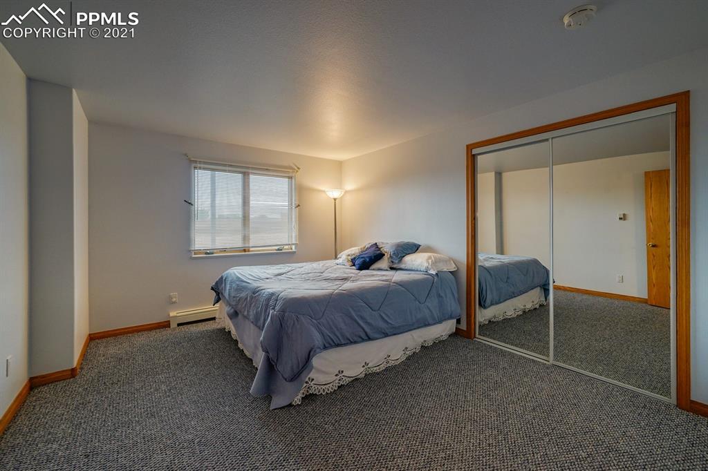 13770 Woodlake Road Elbert, CO 80106 - Photo 18 of 43 a spacious bedroom with a bed and a cabinets