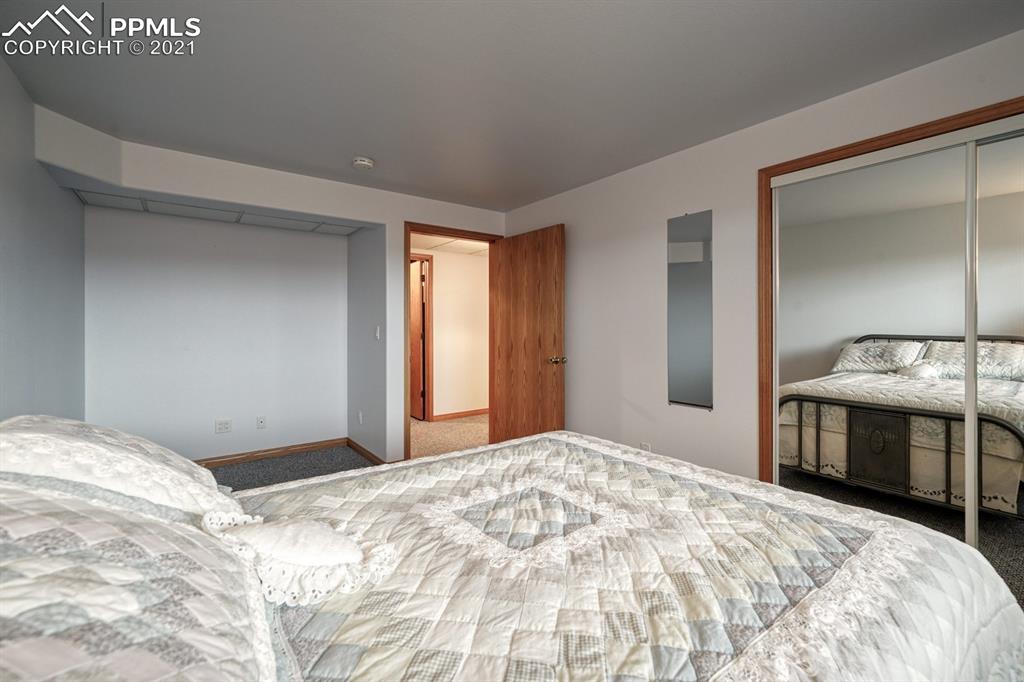 13770 Woodlake Road Elbert, CO 80106 - Photo 20 of 43 a bedroom with a bed and a large mirror