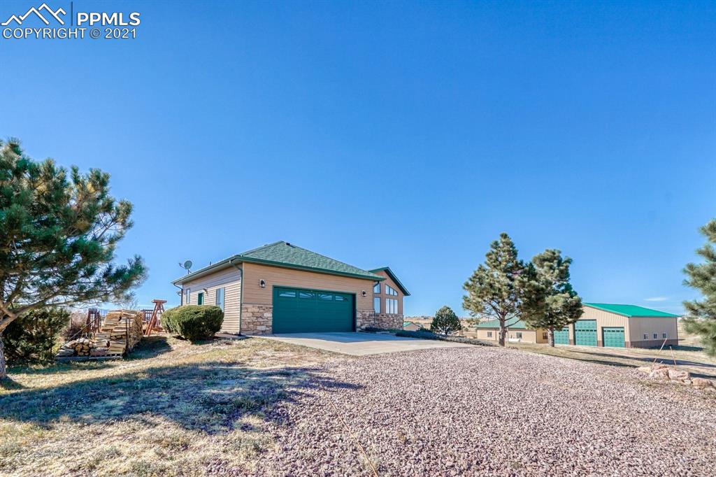 13770 Woodlake Road Elbert, CO 80106 - Photo 34 of 43 a front view of a house with a yard and garage