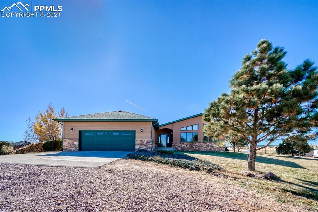 13770 Woodlake Road Elbert, CO 80106 - Photo 35 of 43 a front view of a house with a yard and garage