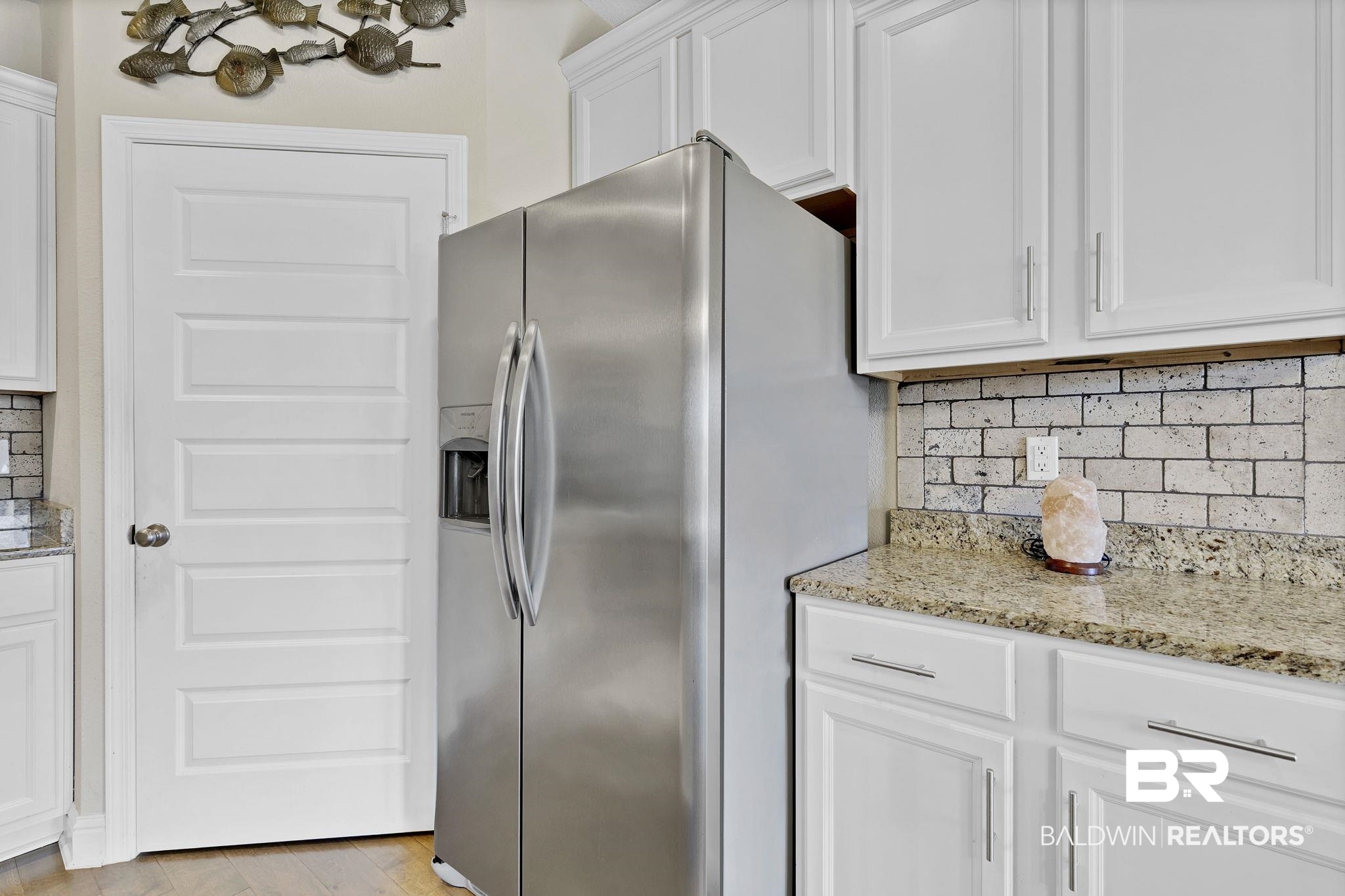 1547 Kairos Loop Foley, AL 36535 - Photo 17 of 55 Kitchen with light stone countertops, stainless steel fridge, backsplash, and white cabinetry