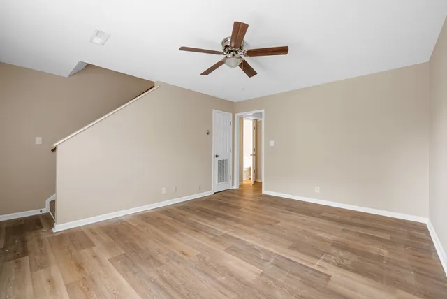 a view of room with wooden floor and ceiling fan
