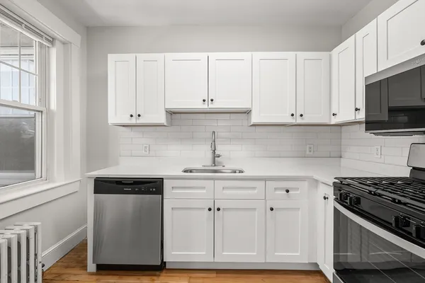 a kitchen with white cabinets and a stove top oven