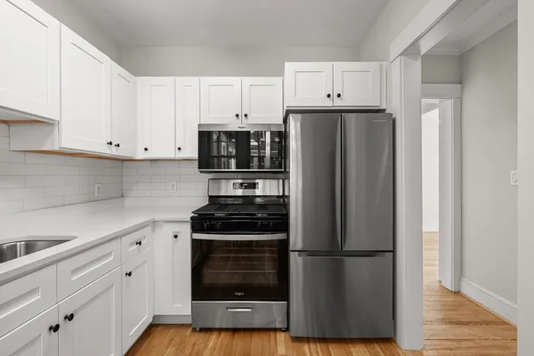 a kitchen with refrigerator a stove a sink and cabinets