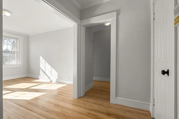 a view of a room with wooden floor and a bathroom