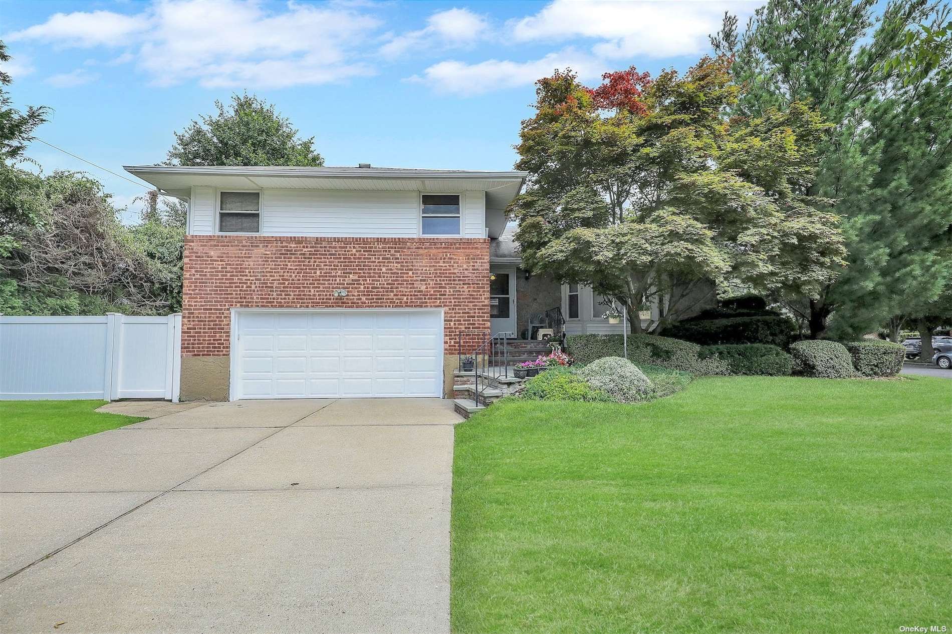 22 Leonard Road Syosset, NY 11791 - Photo 1 of 1 a front view of a house with a yard and garage