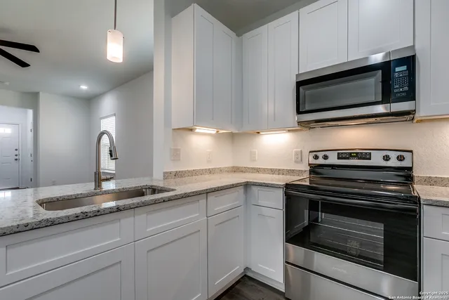 a kitchen with granite countertop a sink and steel stove