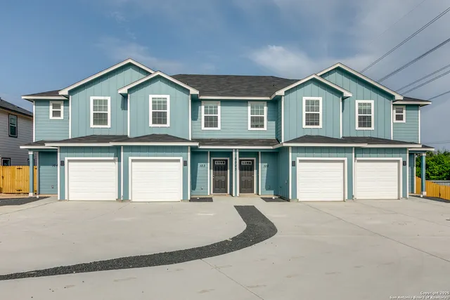 a front view of a house with yard and parking