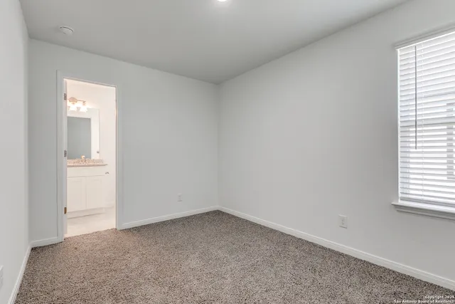 an empty room with windows & cabinet