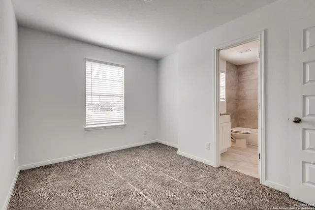 an empty room and a bathroom with toilet