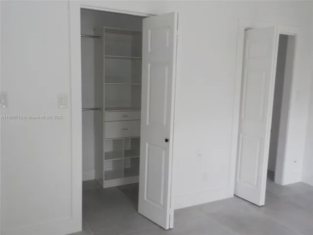 a kitchen with stainless steel appliances kitchen island granite countertop a sink and a refrigerator