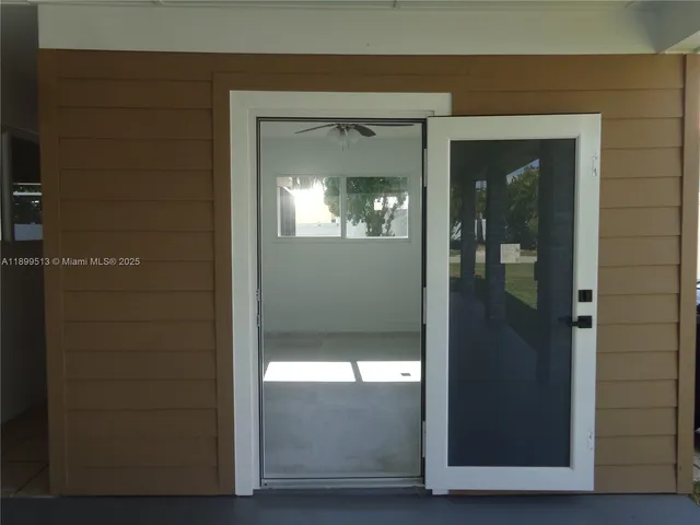 a view of a big room with windows and chandelier