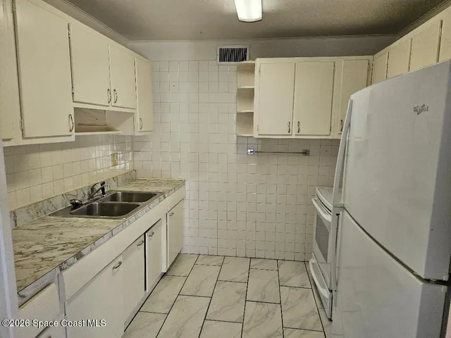 a kitchen with a stove a refrigerator and a sink