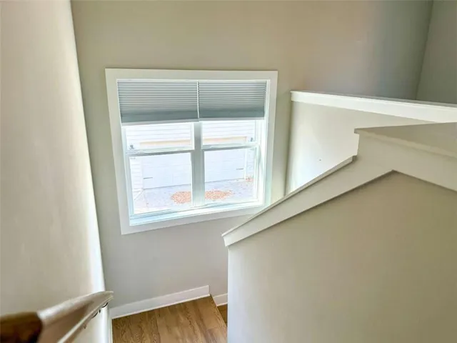 an empty room with chandelier fan and windows