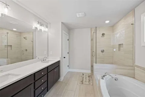 a bathroom with a tub a double vanity sink a window and a mirror