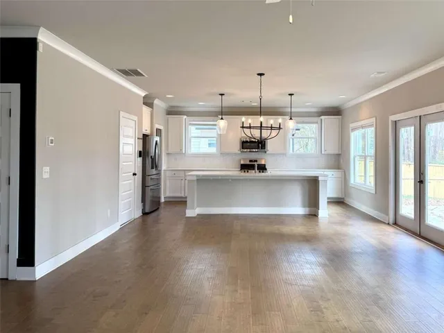 a large kitchen with stainless steel appliances a large counter top a refrigerator and a sink