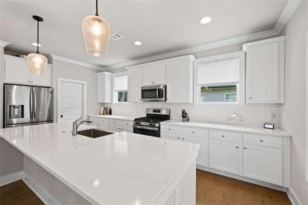 2362 Browns Mill Road Southeast Atlanta, GA 30315 - Photo 8 of 41 a kitchen with stainless steel appliances a stove a sink a microwave a center island and cabinets