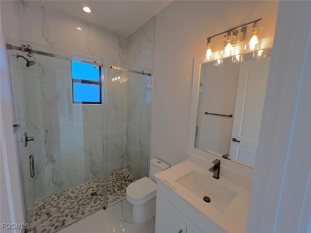 3672 68th Avenue Northeast Naples, FL 34120 - Photo 12 of 18 a bathroom with a sink a toilet and shower