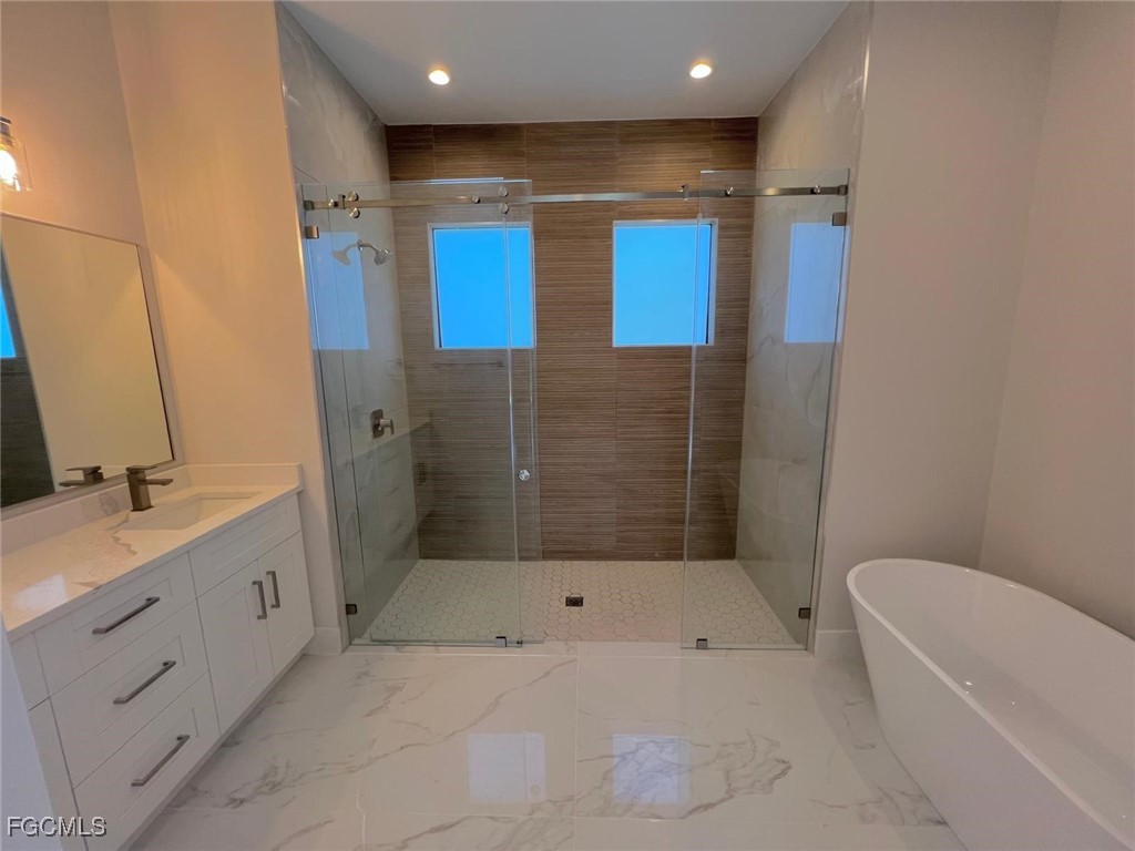 3672 68th Avenue Northeast Naples, FL 34120 - Photo 7 of 18 a bathroom with a mirror a bathtub and a shower