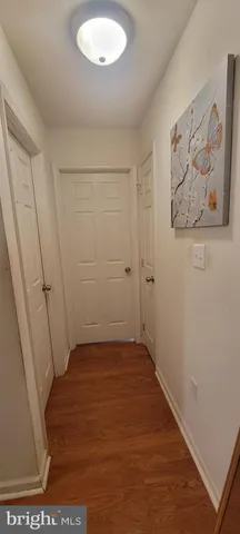 an empty room with wooden floor and window