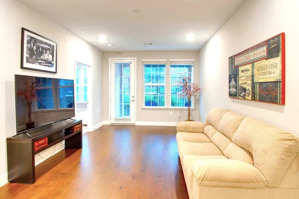 a living room with furniture and a flat screen tv with wooden floor