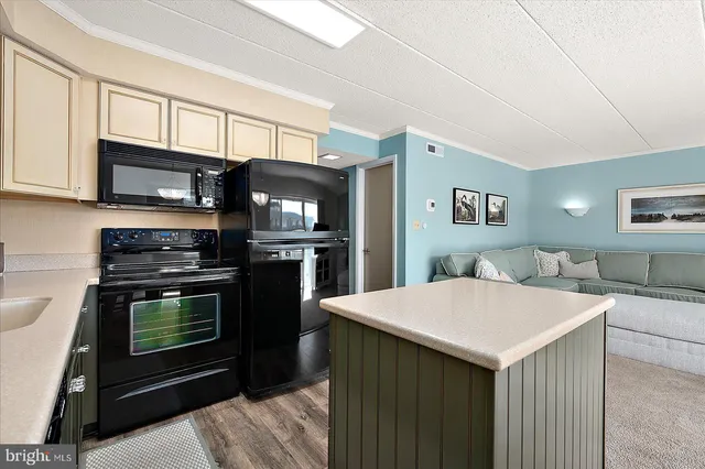 a kitchen with stainless steel appliances a stove a microwave and white cabinets