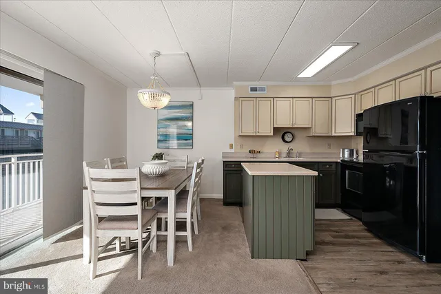 a kitchen with a table chairs refrigerator and cabinets