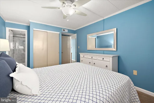 a bedroom with a bed and a flat tv screen on dresser