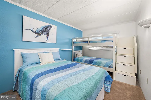 a bedroom with two bed and a painting on the wall