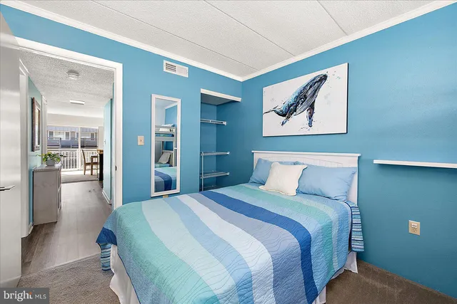 a bedroom with a bed and a painting on the wall