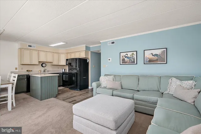 a living room with furniture and kitchen view