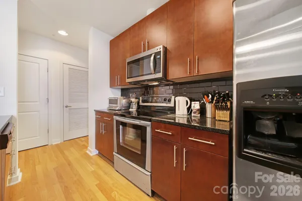 a kitchen with stainless steel appliances granite countertop a stove a sink and a microwave