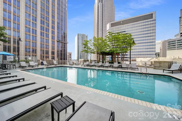 a view of swimming pool with outdoor seating and lake view