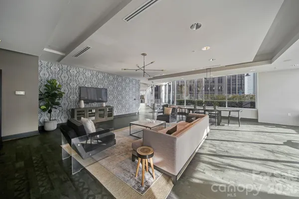 a living room with furniture a flat screen tv and a large window
