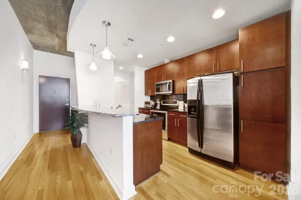 a kitchen with stainless steel appliances a refrigerator and a stove top oven