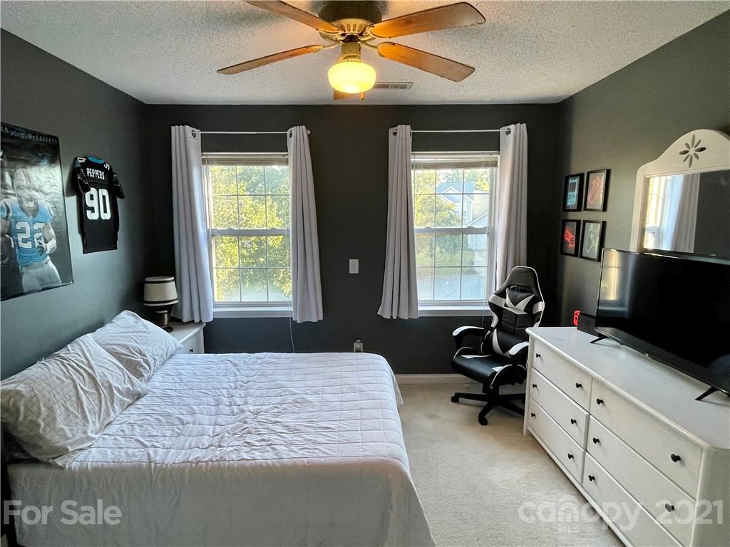 6607 Reedy Creek Road Charlotte, NC 28215 - Photo 20 of 27 a bedroom with a bed and a chandelier