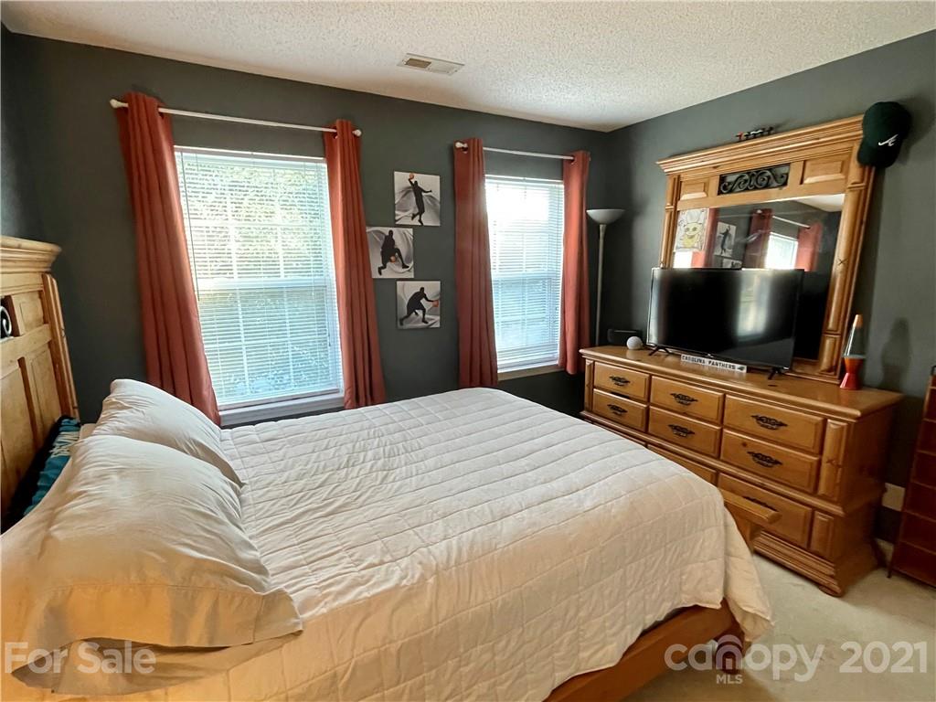 6607 Reedy Creek Road Charlotte, NC 28215 - Photo 23 of 27 a bedroom with a bed and a flat screen tv
