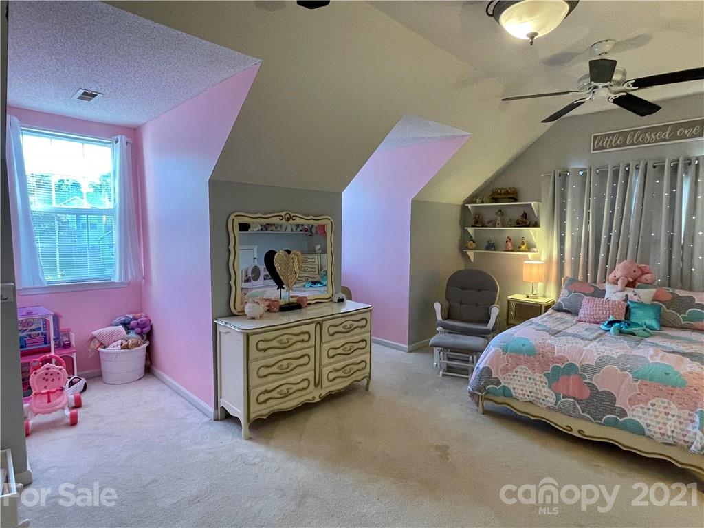 6607 Reedy Creek Road Charlotte, NC 28215 - Photo 25 of 27 a bedroom with a bed and a lamp on dresser