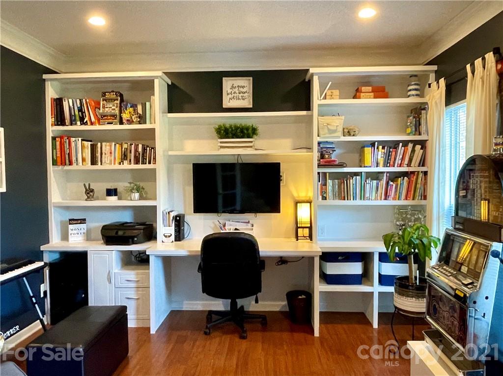 6607 Reedy Creek Road Charlotte, NC 28215 - Photo 5 of 27 a livingroom with a bookshelf and a workspace