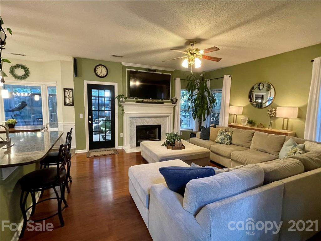 6607 Reedy Creek Road Charlotte, NC 28215 - Photo 9 of 27 a living room with furniture a flat screen tv and a fireplace