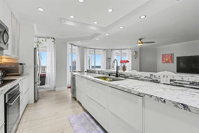 a kitchen with stainless steel appliances kitchen island granite countertop a stove microwave and refrigerator