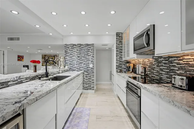 a living room with furniture a refrigerator and kitchen view