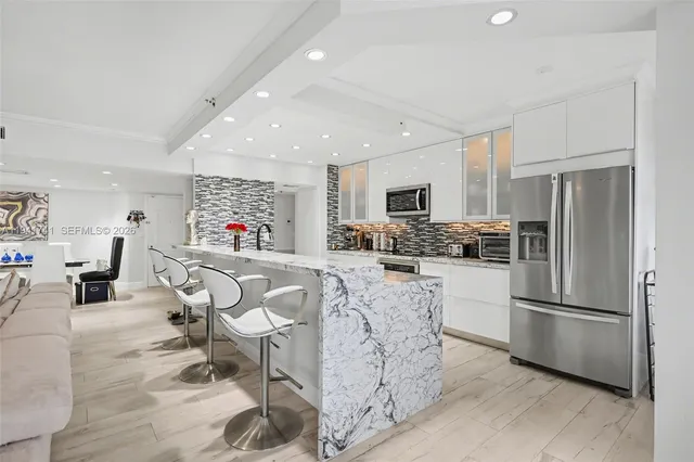 a living room with furniture kitchen view and a chandelier