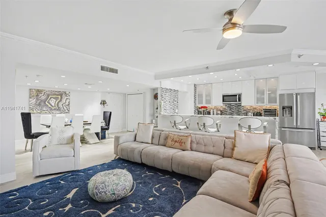 a living room with furniture and a refrigerator