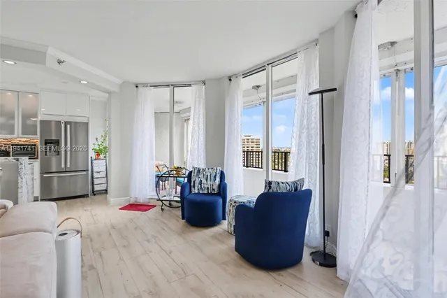a living room with stainless steel appliances kitchen island granite countertop furniture and a view of kitchen