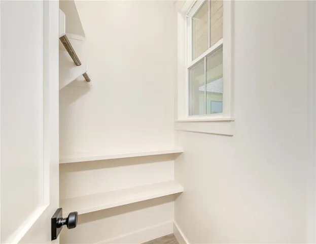 an empty room with a window and a ceiling fan