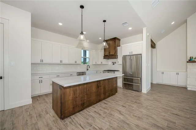 a kitchen with stainless steel appliances a sink cabinets and wooden floor