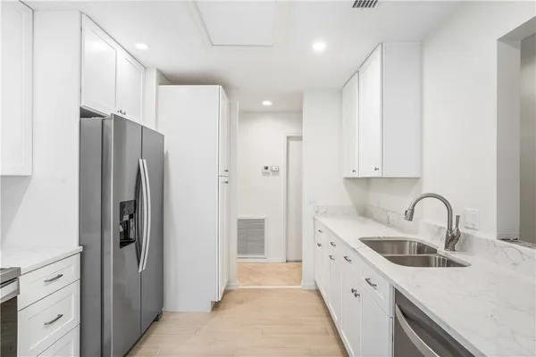 a kitchen with stainless steel appliances a refrigerator sink and cabinets
